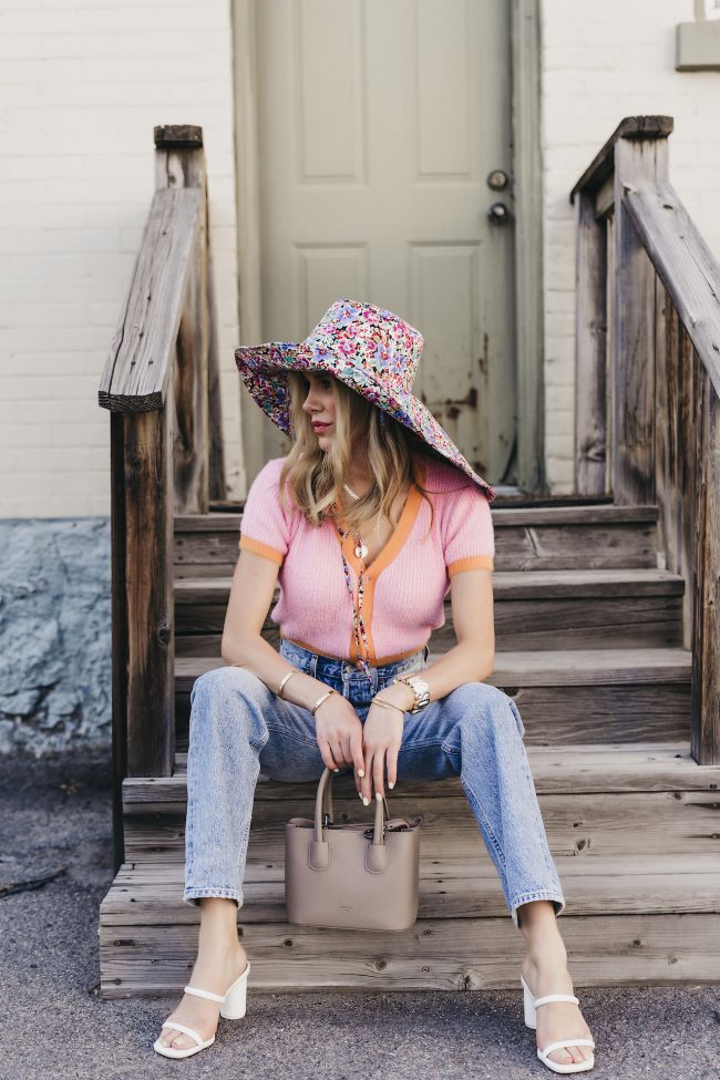 street style blogger wearing a floral bucket hat with agolde denim and a cropped bright sweater