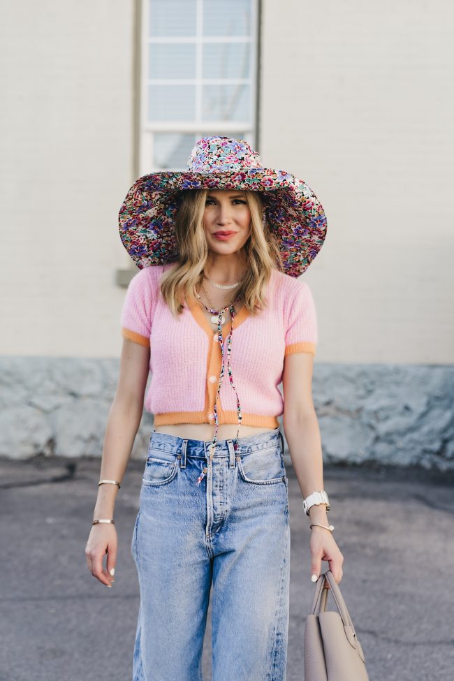 the fashion fuse wearing a cropped colorful sweater and a summer floral hat