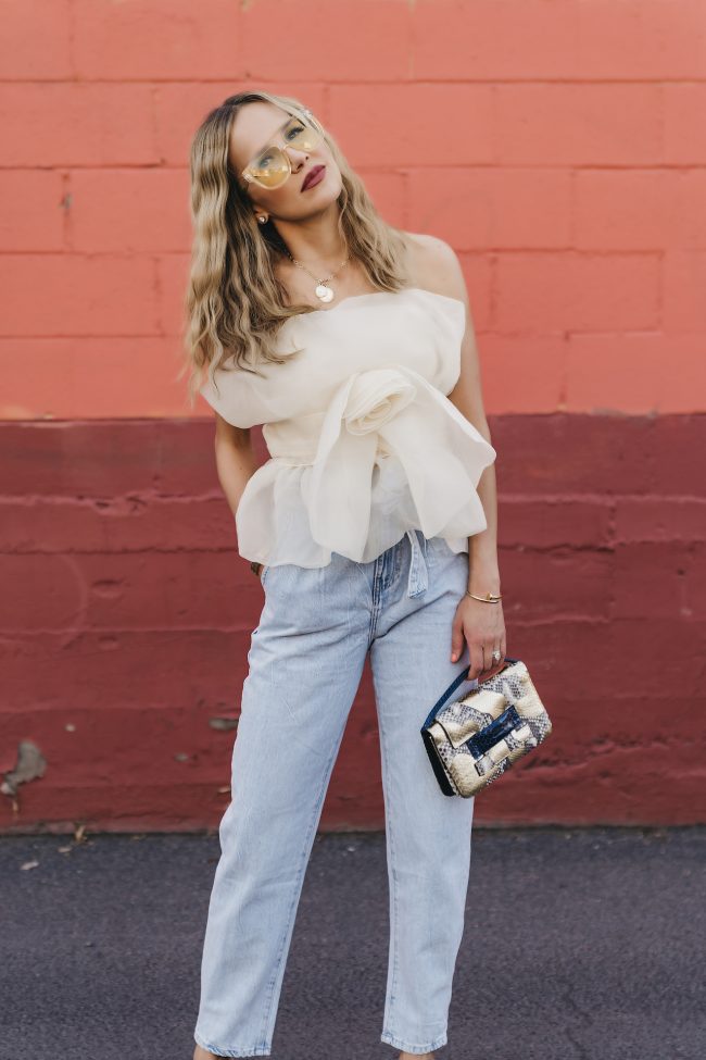 Street style blogger wearing a whimsical top and statement vintage denim