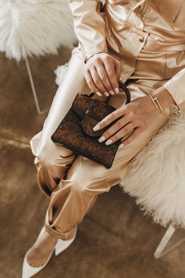 Utah Fashion Fuse blogger wearing a croc-embossed leather mini bag and a gold jumpsuit made of faux leather in the fall