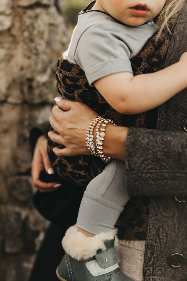 SLC style blogger wearing gold beaded accessories and a baby carrier is artipoppe